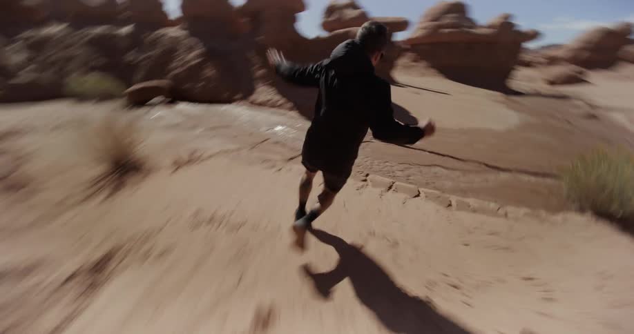 Man running outdoors among desert rocks