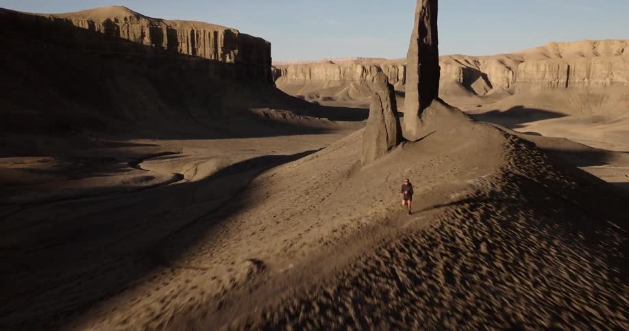 Man running in a desert landscape with mountains around