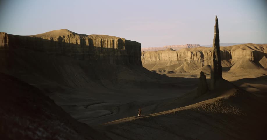 A man runs through the shade of the mountain