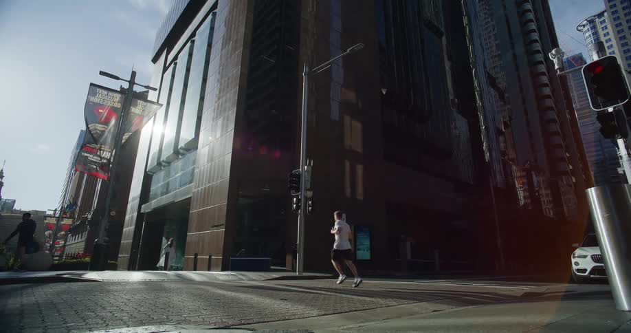 Man running across the street in a big city during the day