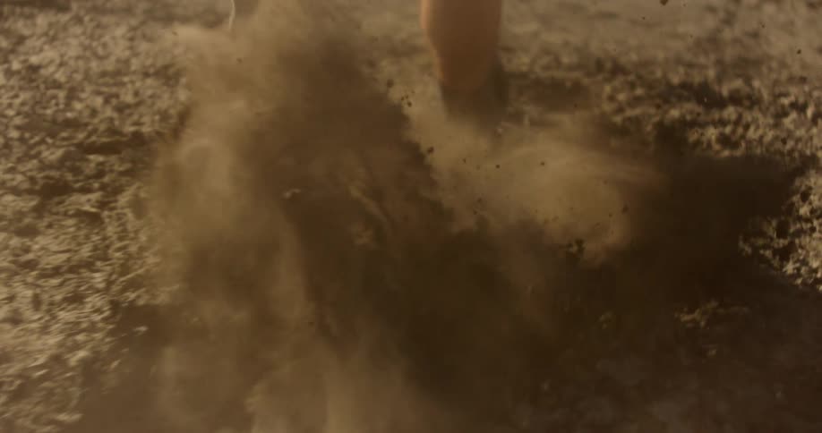 Close up of a persons legs running on dirt