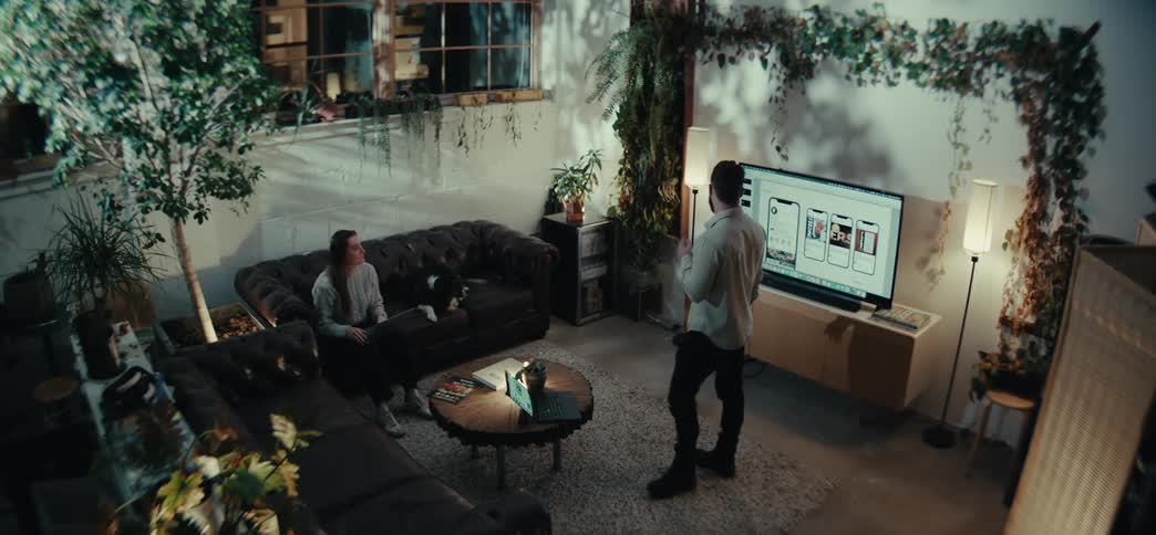 Man standing in a room talking to a woman sitting in an armchair