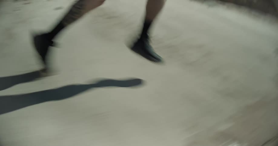 Close up of the legs of a person running in a desert landscape
