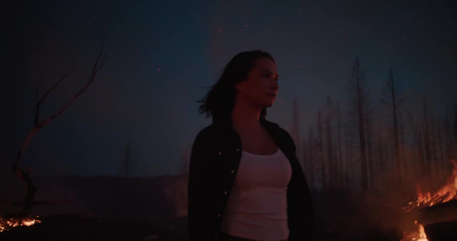 Woman in a night scene of a forest on fire
