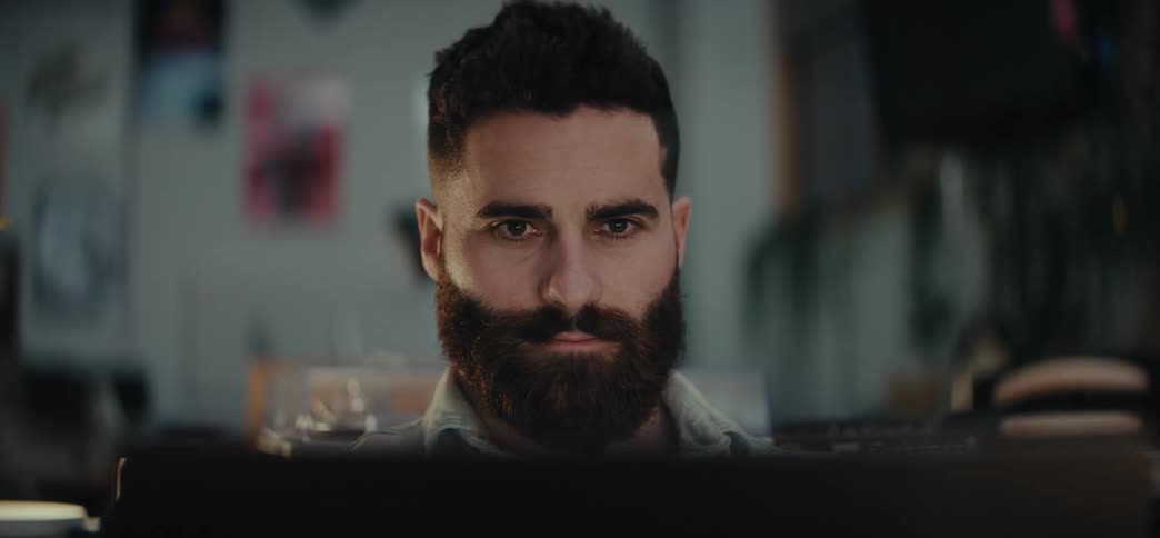 Portrait of a man sitting in front of a laptop