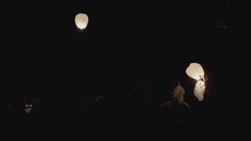 People are sending lanterns up into the air at night