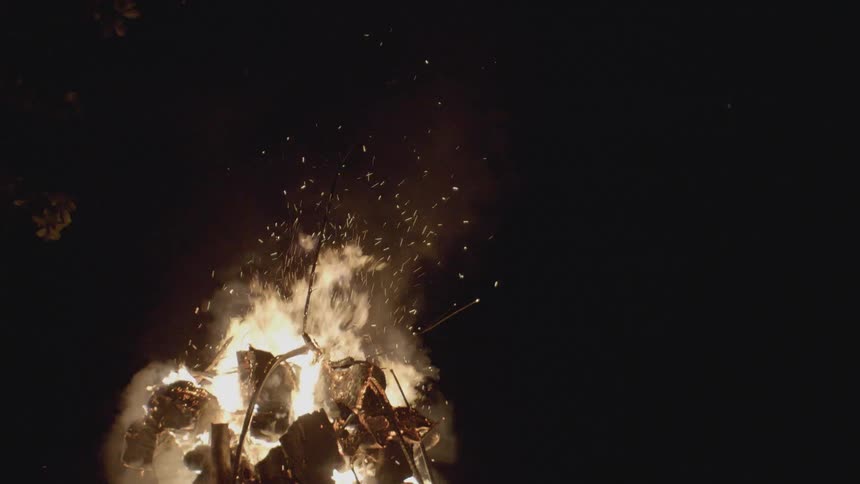 A raging campfire burns