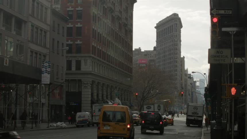 Cars travel on a city street on an overcast day