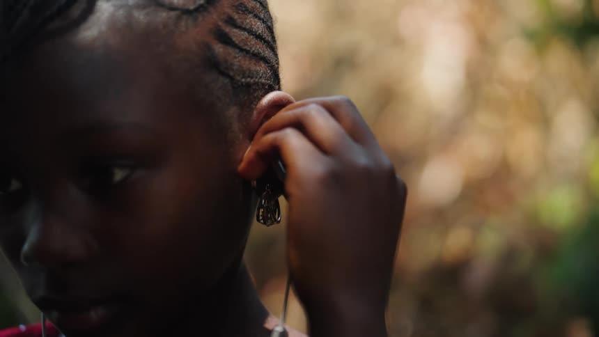 Portrait of a girl putting an earphone in her ear