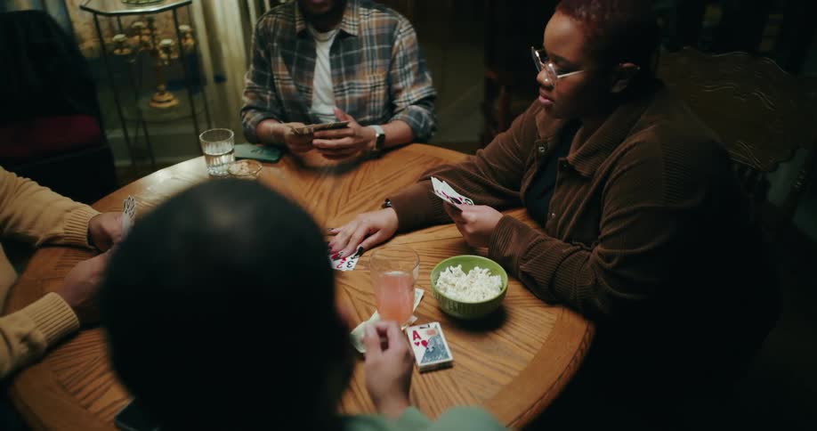 A group of friends or family plays cards and has fun in a cozy room at home