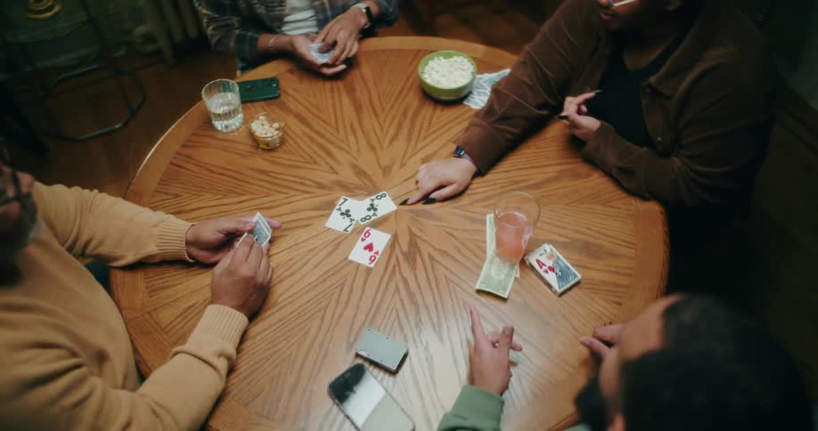 A group of friends or family plays cards and has fun in a cozy room at home