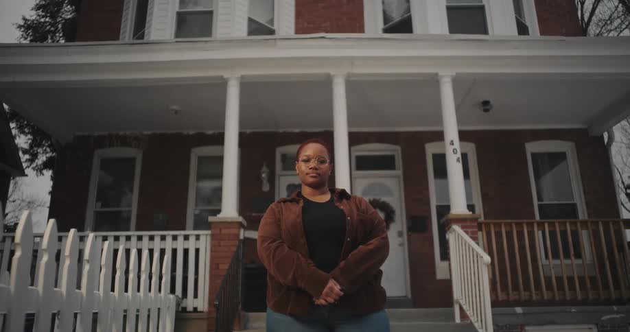 Woman with glasses in front of a house