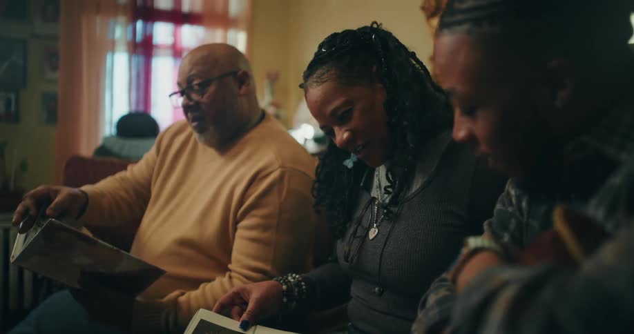 A footage of a family looking at a photo album indoor