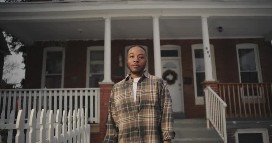 A clip of a male standing outside the house