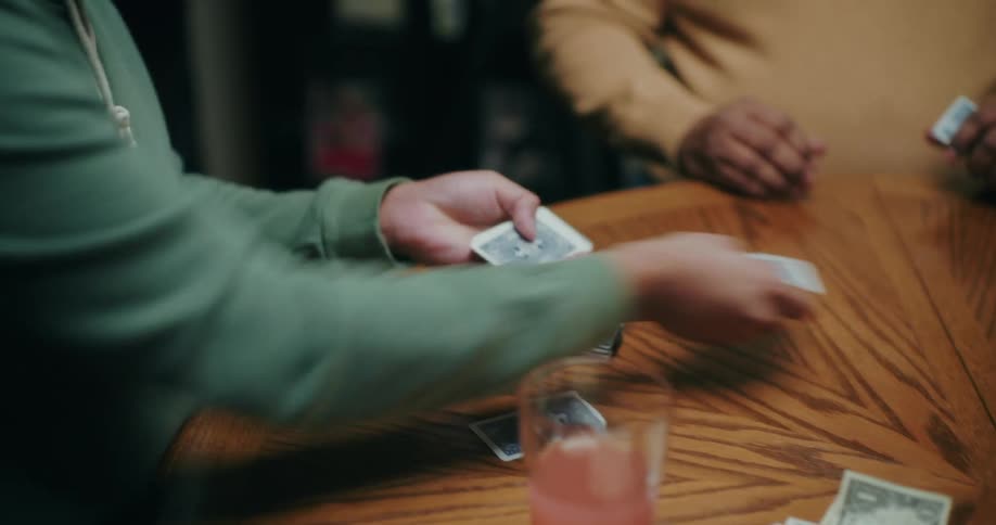 Person taking a deck of cards and distributing them to participants at a table