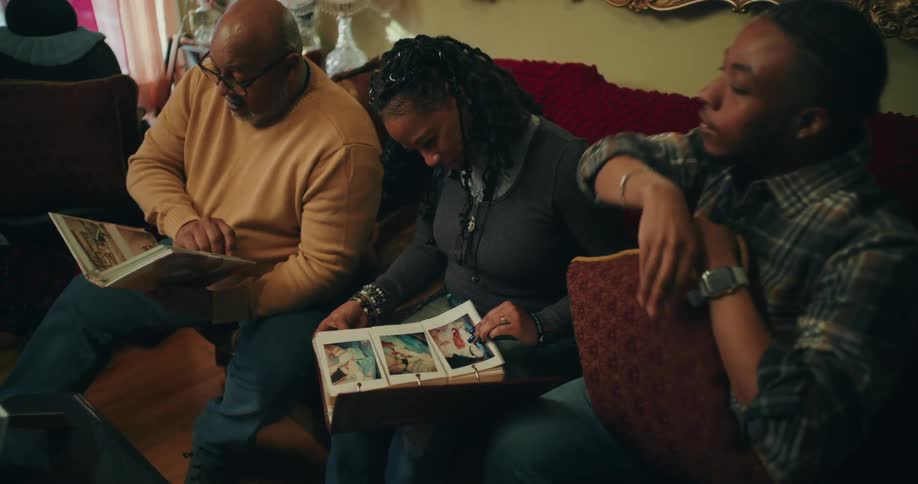 Family members sitting in the living room look through photo albums