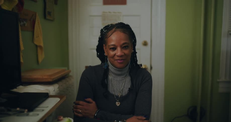 Woman with arms crossed and happy facial expression while sitting on a chair