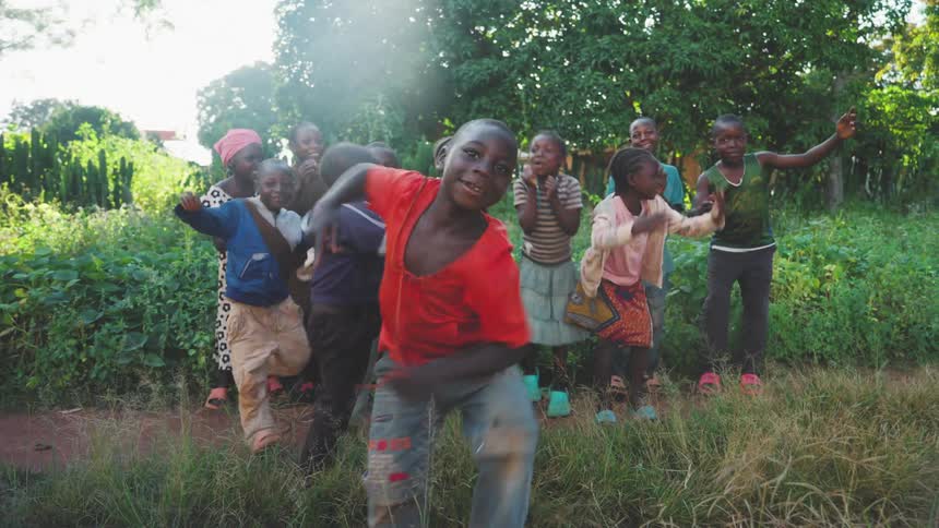 A group of children are dancing on the farm