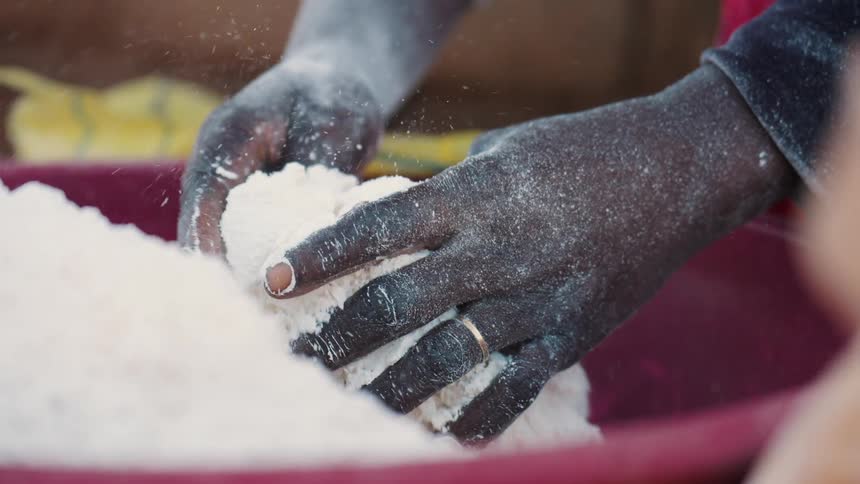 A person is mixing powder in a large bowl