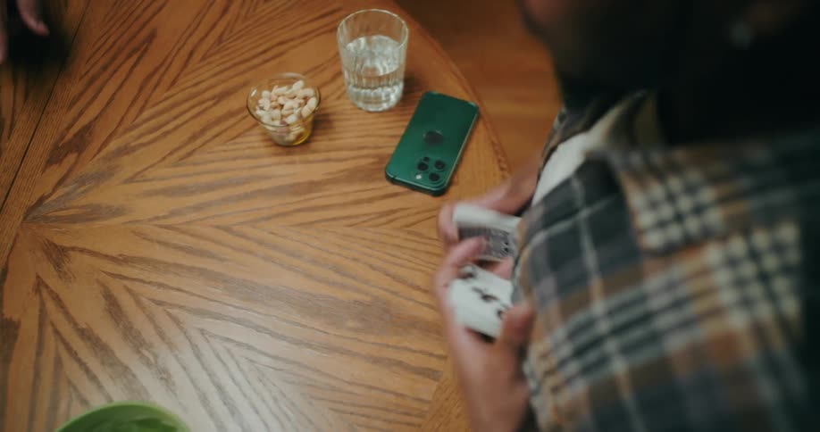 Pair of hands of a man shuffling cards on the table