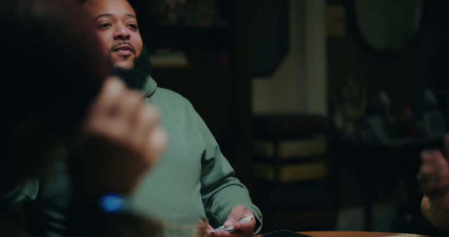 Small group of people sitting at a table playing cards