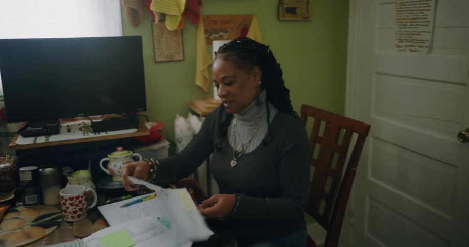 A woman is talking as she reads mail