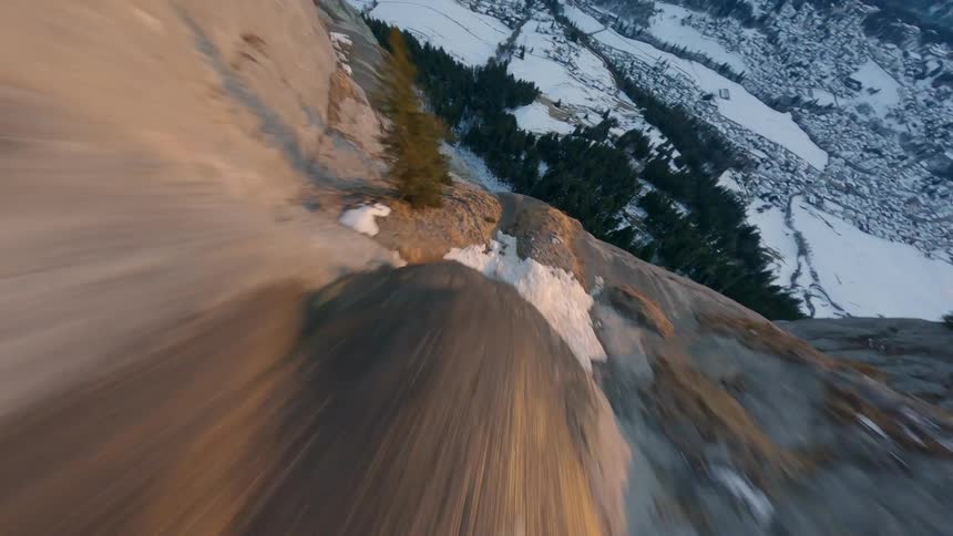 Aerial panorama of a mountain valley surrounded by coniferous forest and snow