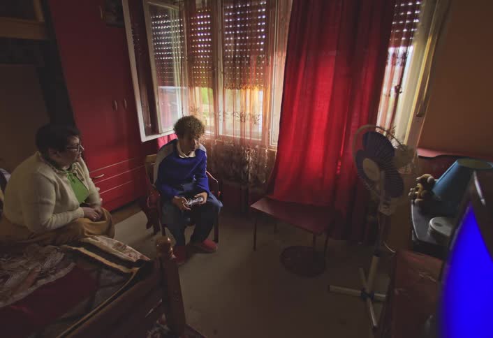 Grandma cheers and watches her grandson playing video games in a room
