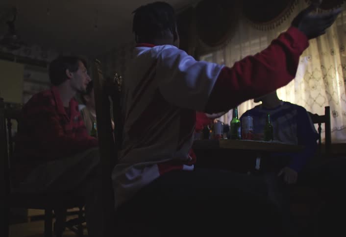 Four happy friends chatting among themselves at a table full of alcoholic drinks