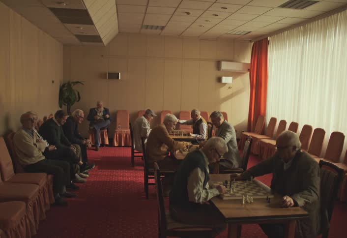 Room with elderly men sitting playing chess