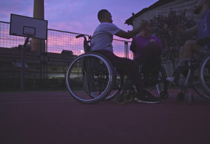 Players in wheelchairs shake hands on the basketball court