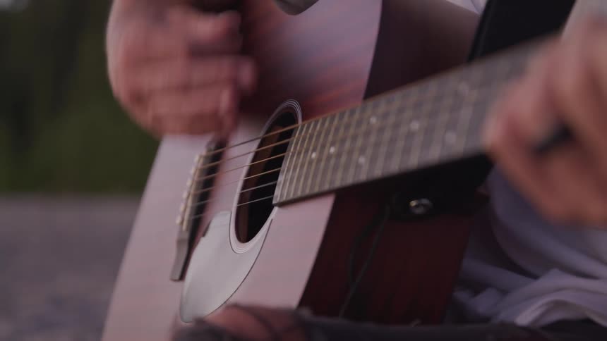 Pair of hands playing a guitar