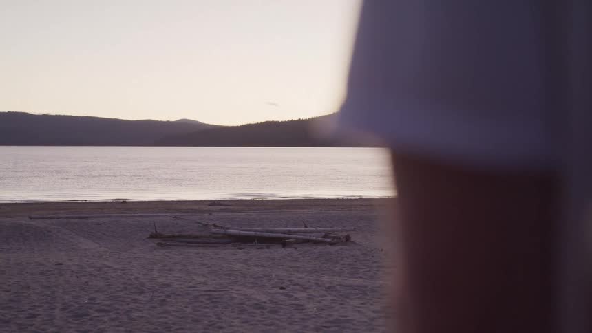 Serene beach at dusk and a figure partially out of focus