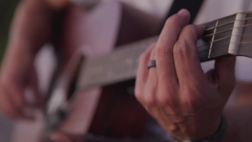 A person is playing music on their guitar