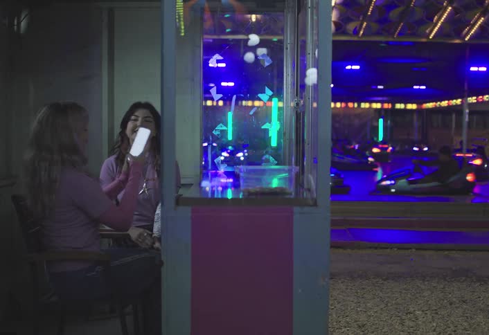 A footage of two ladies sitting and taking photos