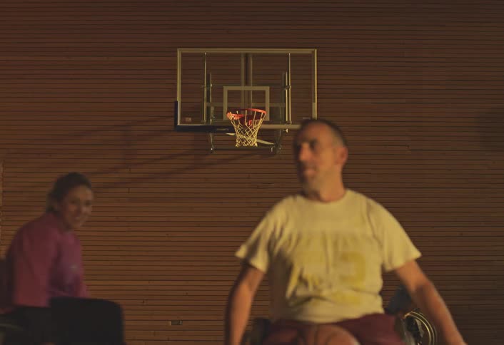 Group of wheelchair users playing basketball on a court