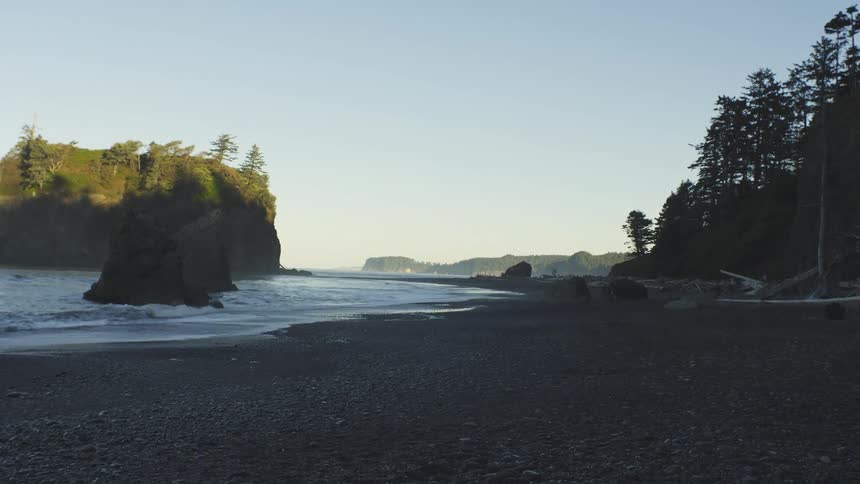 Landscape at dawn of a beach with a wooded coastline around