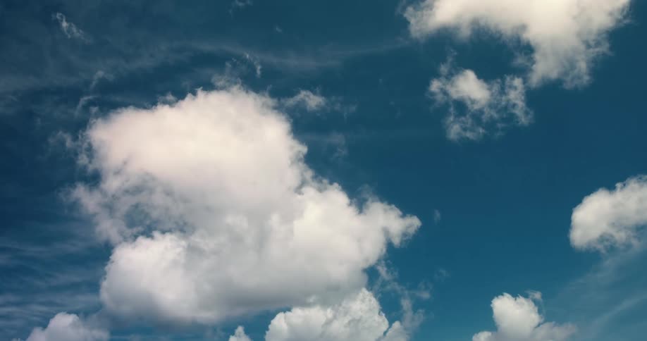 Time lapse of white clouds drifting through a vibrant blue sky