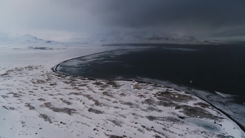Aerial view of snowcovered land by the sea