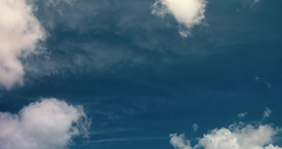 Time lapse of white clouds drifting through a vibrant blue sky