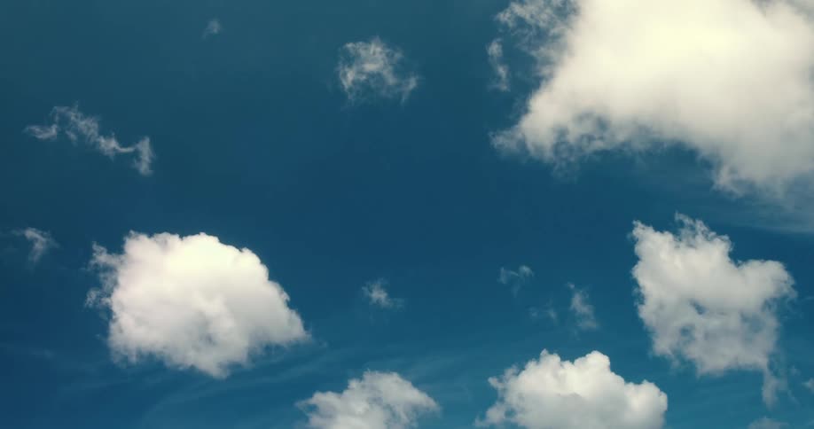 Time lapse of white clouds drifting through a vibrant blue sky