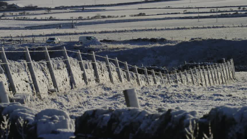 A grass field with a wooden fence in the region