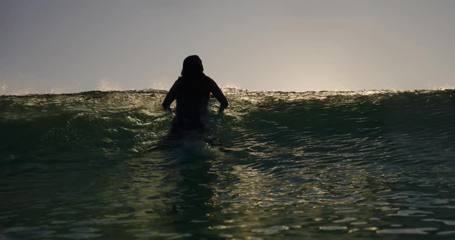 Silhouette of a surfer riding a wave in the ocean