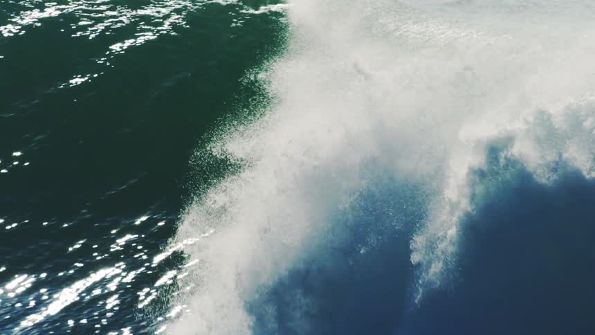 A powerful wave violently crashes onto a rocky shore sending white spray into the air