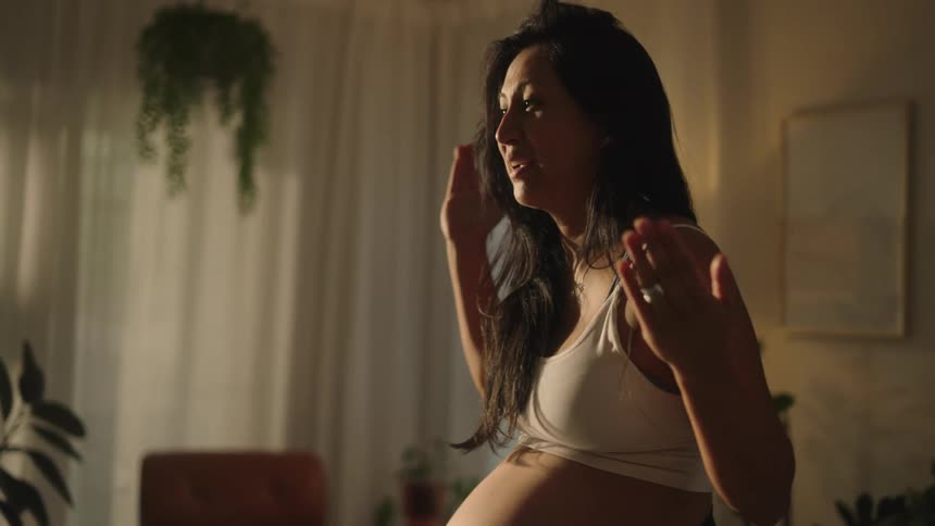 Pregnant woman talking in front of a smartphone on a tripod
