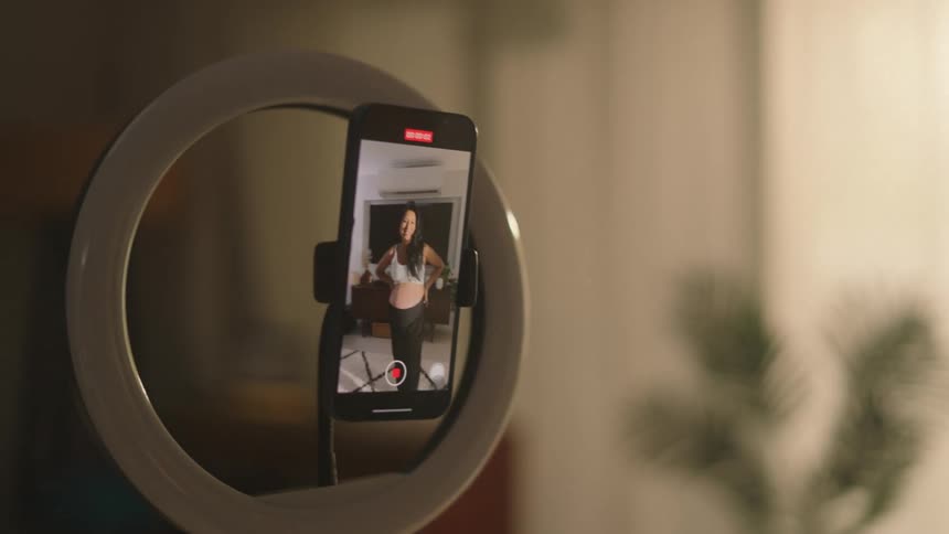Pregnant woman recording herself on a smartphone