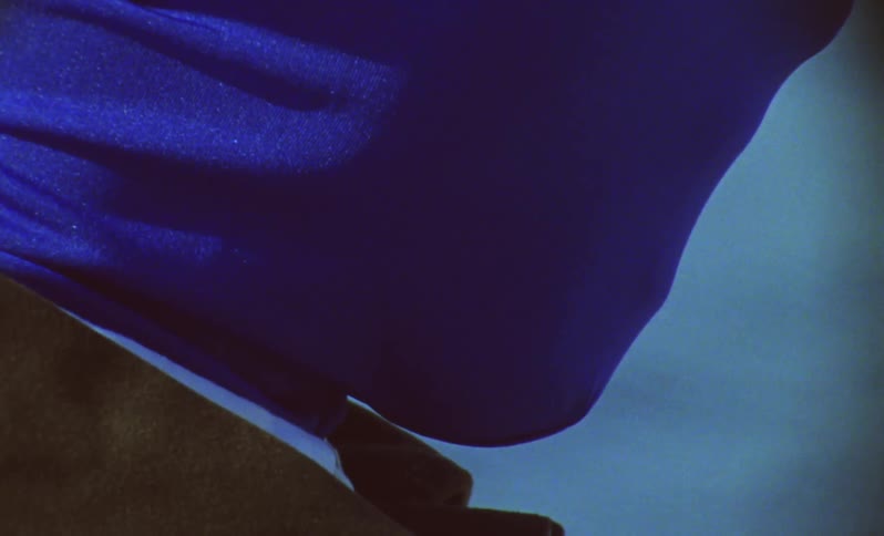 Man with his entire face covered by a blue mask by the lake