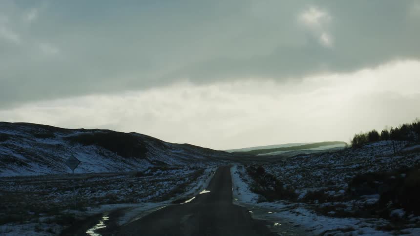 A small road runs over the ice covered hills