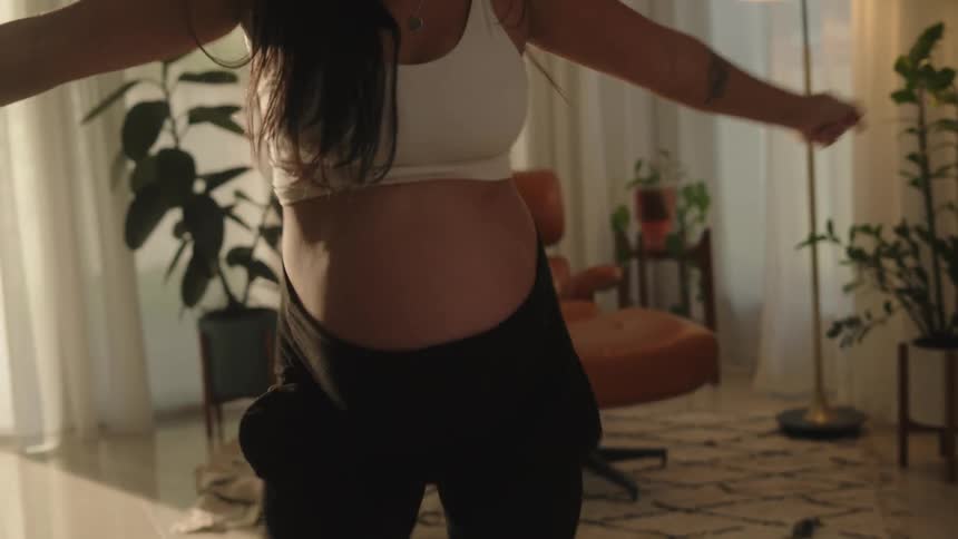 Pregnant woman in living room dancing