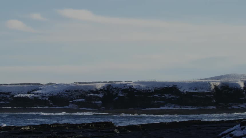 Landscape of ocean surrounded by snowy mountains